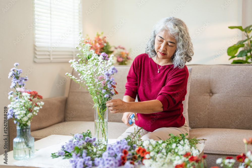 elderly woman holding flowers. Beautiful aged woman with a bouquet at home on a holiday. Old woman decorating a vase with flowers at home elderly woman holding flowers. Beautiful aged woman with a bouquet at home on a holiday. Old woman decorating a vase with flowers at home