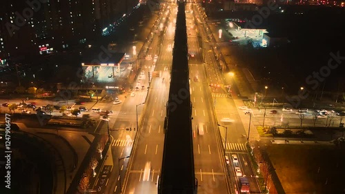 Nighttime aerial view of bustling city traffic captured in a time-lapse from a unique perspective