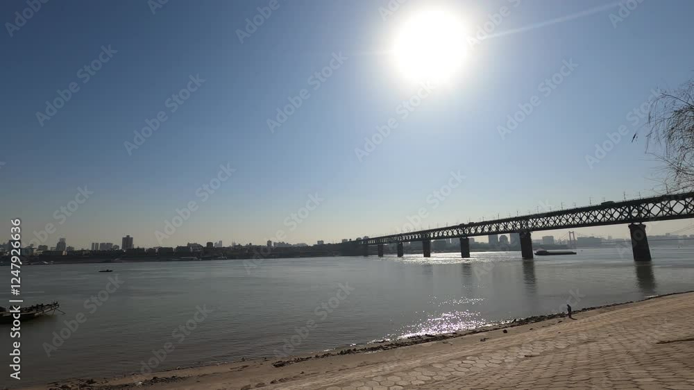 Time lapse of clear weather over Yangtze River and Wuhan bridge with a ship sailing in the sunlight Time lapse of clear weather over Yangtze River and Wuhan bridge with a ship sailing in the sunlight