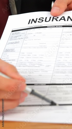 Mid section of businessman sitting at desk holding insurance contract