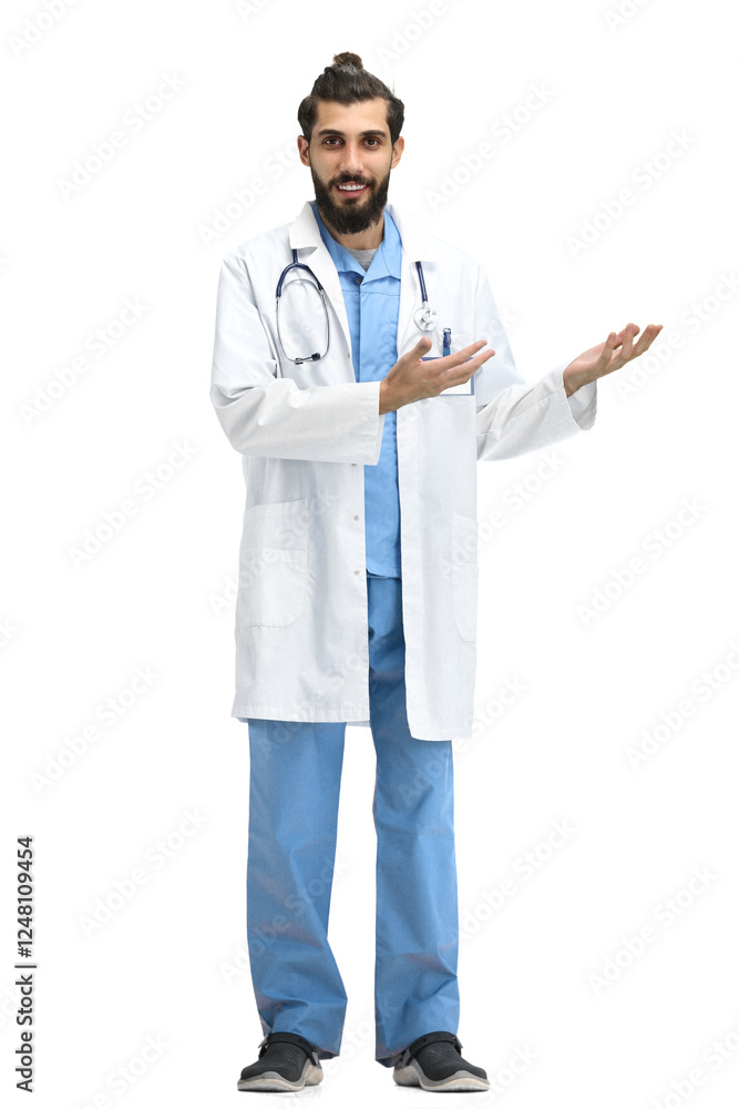 The male doctor, full-length, on a white background, points to the side The male doctor, full-length, on a white background, points to the side