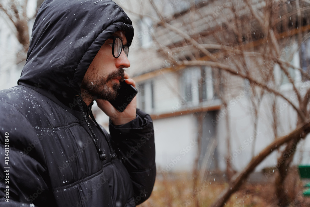 A young man in casual style walks through the snowy city on a winter day, chatting on his phone and sipping coffee. The lifestyle photo captures his relaxed, modern vibe and cheerful energy in an urba A young man in casual style walks through the snowy city on a winter day, chatting on his phone and sipping coffee. The lifestyle photo captures his relaxed, modern vibe and cheerful energy in an urba