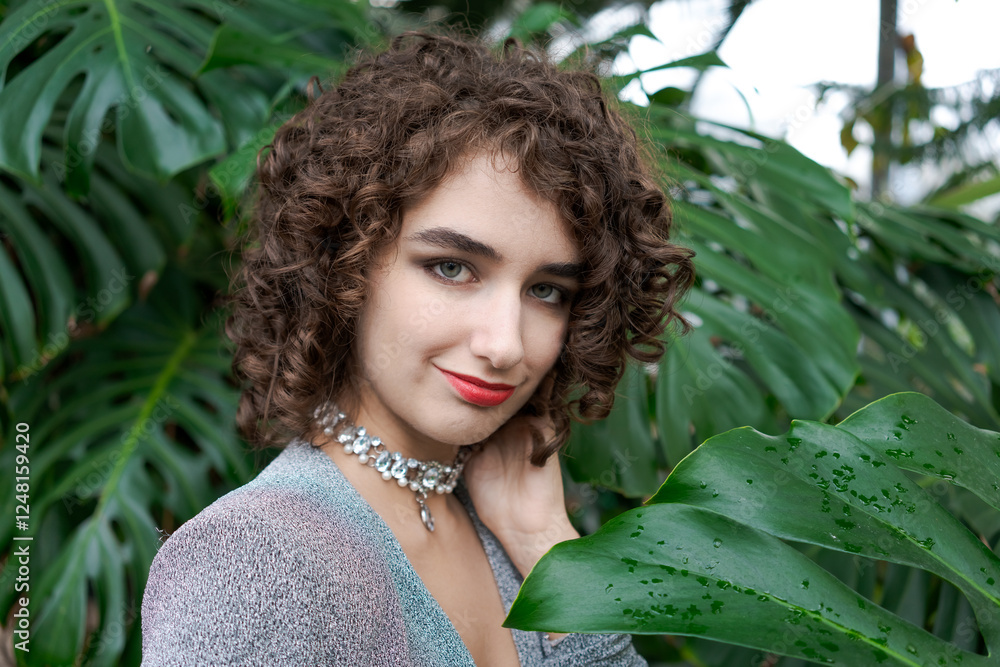 Woman with curly hair is wearing a necklace and a red lipstick Woman with curly hair is wearing a necklace and a red lipstick