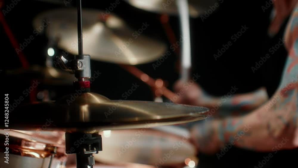 Playing rock music, closeup view of drum set and drumsticks in hands of musician . Details of musical instruments, cool rock band performing in contemporary concert hall, professional musician playing