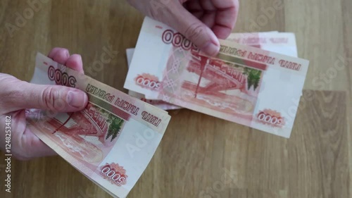 The currency of Russia. Close-up of Russian rubles. Financial concept. The background and texture of banknotes. The woman's hands count the 5000 rubles banknotes