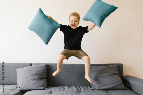 Happy Boy Jumping On Sofa