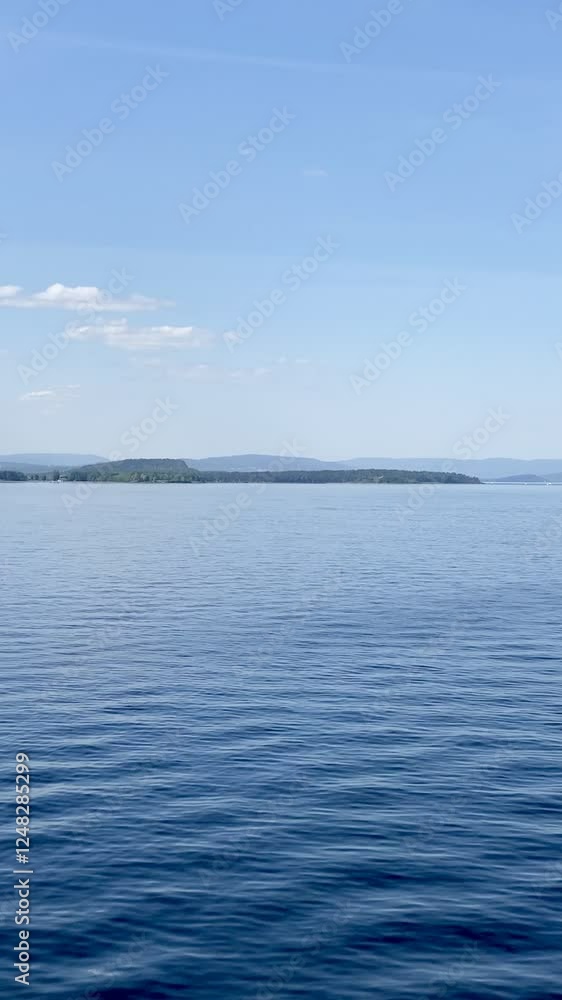 Sailing on the Oslofjord on a bright summer day in calm blue waters Sailing on the Oslofjord on a bright summer day in calm blue waters