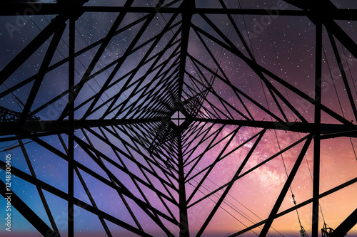 Perspective view of a high-voltage power tower silhouetted against a starry night sky, symbolizing energy and technological progress
