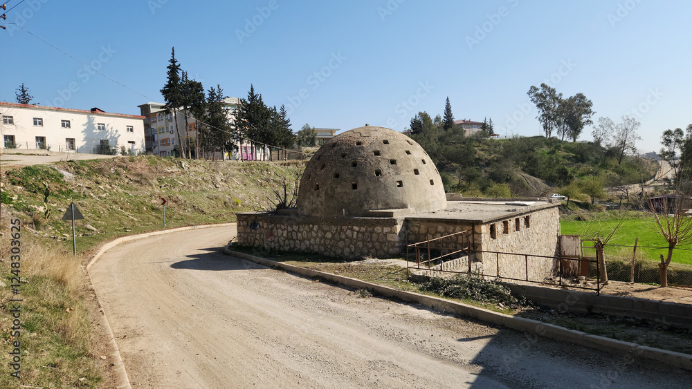 An old, deserted bath house (hamam) remains a historical relic, with its crumbling walls and vacant chambers resonating with the tales of a long-gone past, enveloped in the murmurs of history. An old, deserted bath house (hamam) remains a historical relic, with its crumbling walls and vacant chambers resonating with the tales of a long-gone past, enveloped in the murmurs of history.