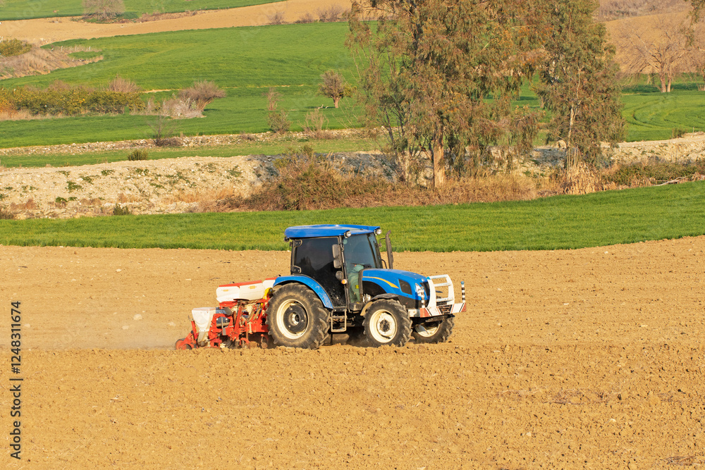 Obraz premium A tractor diligently plants seeds in a crop field, its powerful engine driving the machinery to cultivate the soil and ensure a successful planting season.