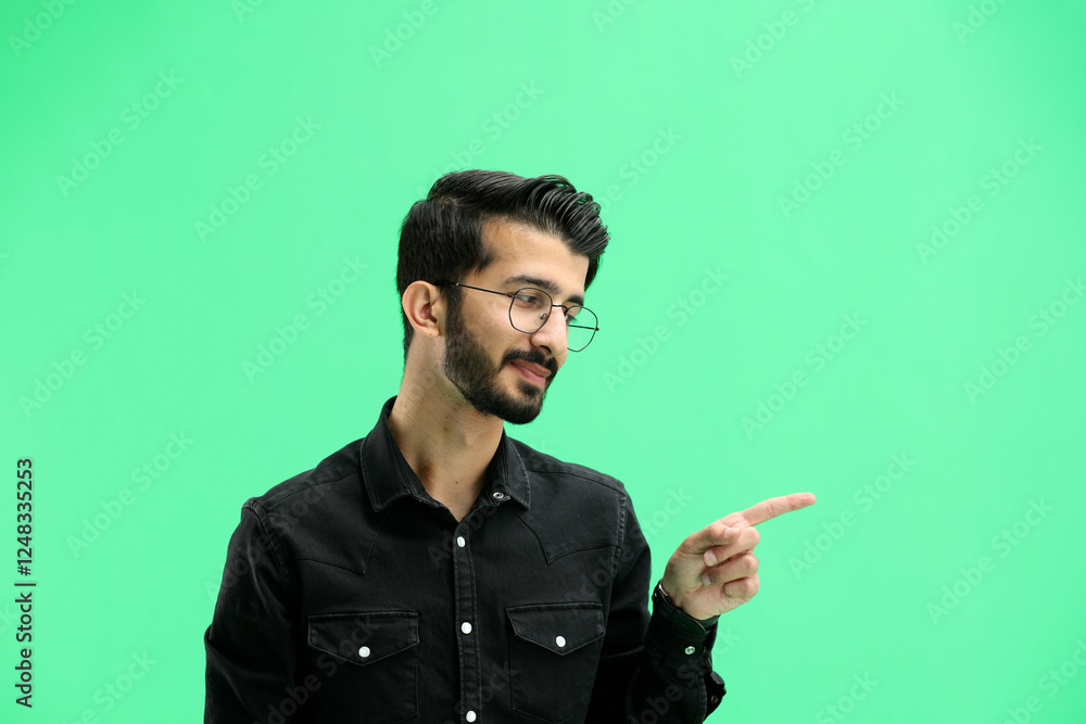 A man, on a green background, in close-up, points to the side A man, on a green background, in close-up, points to the side