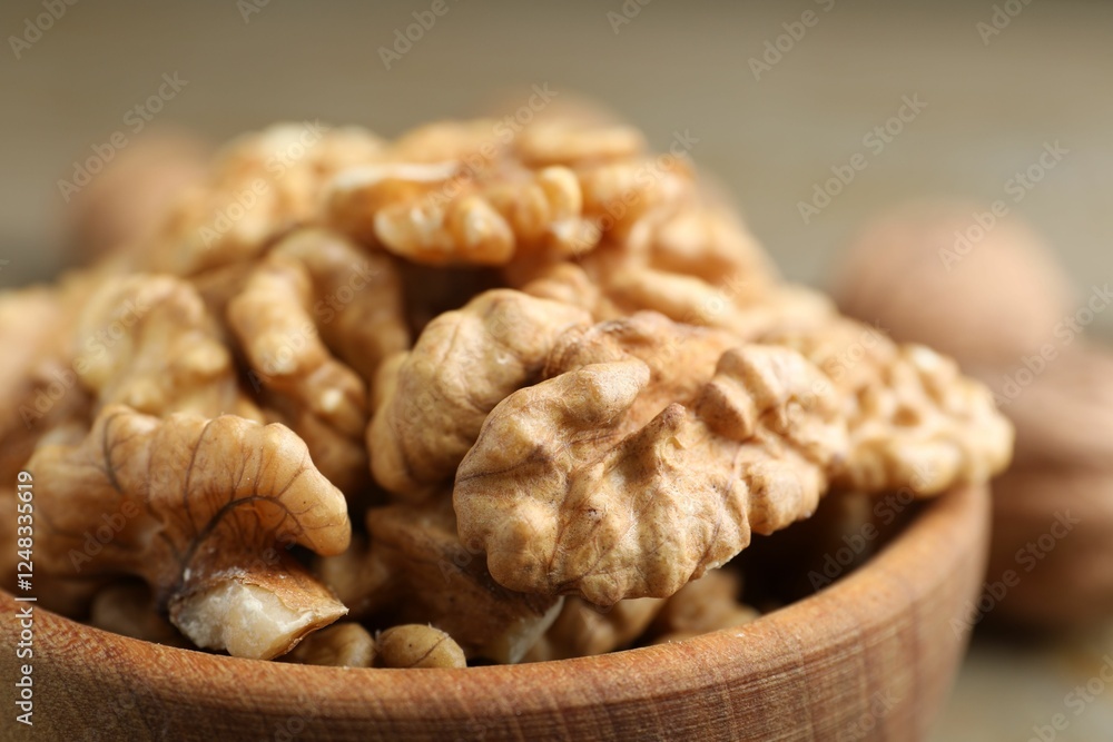 Peeled walnuts in bowl on table, closeup