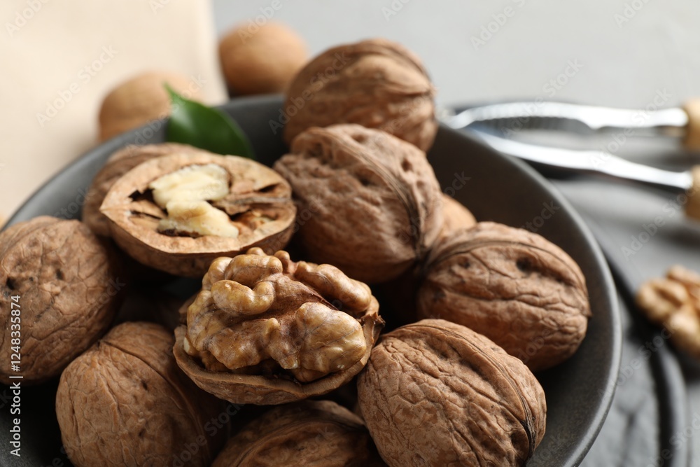 Fresh walnuts in bowl on table, closeup