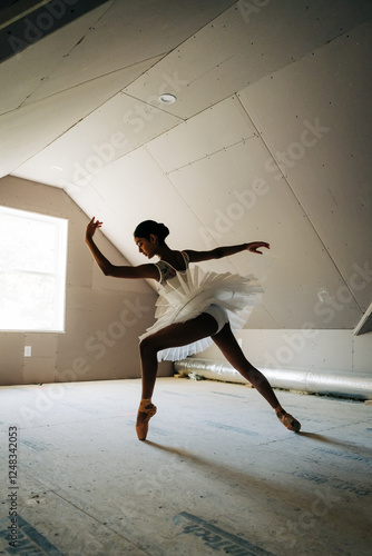 Ballerina in a white tutu striking a dynamic pose in soft silhouette photo