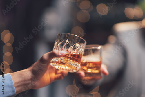 Canvas Print Cheers to Connection: Two hands clink glasses of amber liquid, a toast to friendship, celebration, or a shared moment of enjoyment, bathed in the soft glow of warm lights