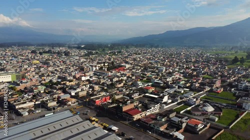 A drone dolly-out shot revealing the city of Machachi, nestled in the province of Pichincha, Ecuador, surrounded by stunning landscapes and local architecture