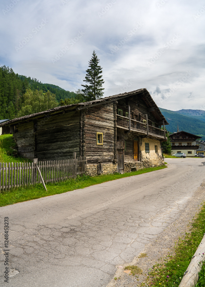 Authentic old wooden house surrounded by green alpine meadows, majestic mountains.Austria, Heiligenblut. Concept: country life, mountain landscape Authentic old wooden house surrounded by green alpine meadows, majestic mountains.Austria, Heiligenblut. Concept: country life, mountain landscape