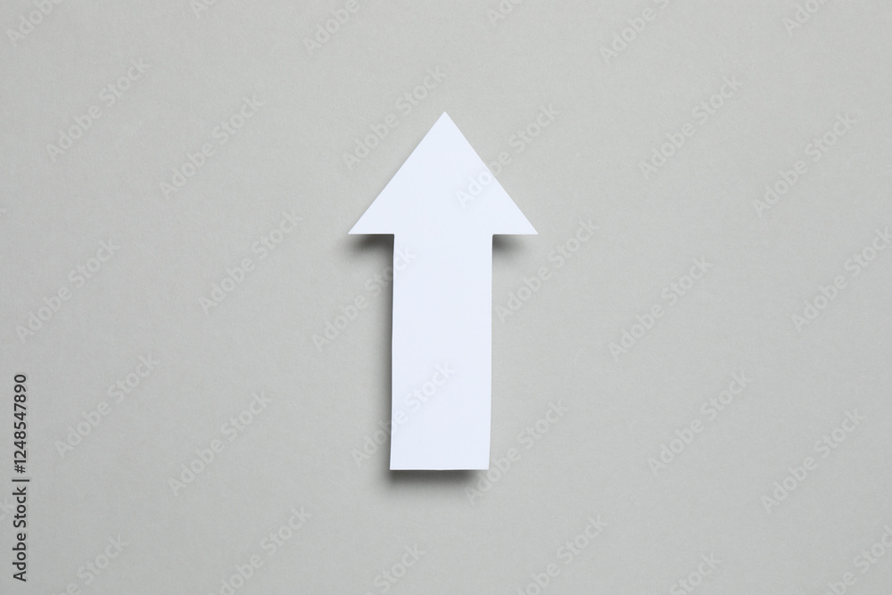 Paper arrow on gray background, top view Paper arrow on gray background, top view