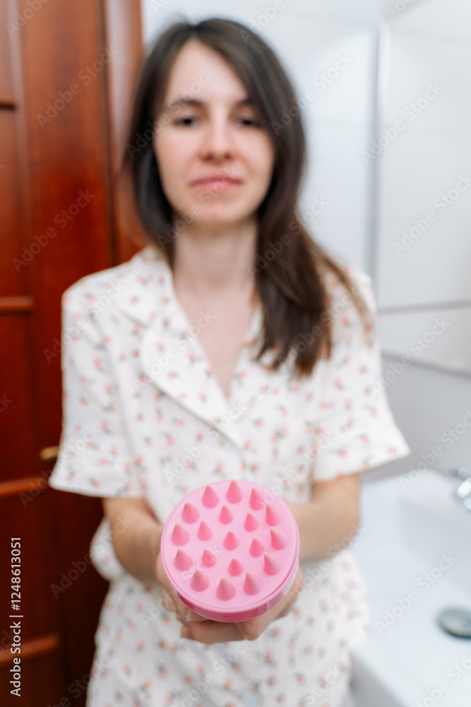 Silicone Exfoliator Massager brush for circulation and follicle stimulation for optimal scalp health in woman hand. Silicone Scrubber in the bathroom Silicone Exfoliator Massager brush for circulation and follicle stimulation for optimal scalp health in woman hand. Silicone Scrubber in the bathroom