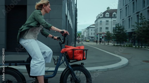 Wallpaper Mural Cute adorable and stylish young woman pedal through town on cargo electric bike. Student or creative office worker cycle in business district on a warm summer morning Torontodigital.ca