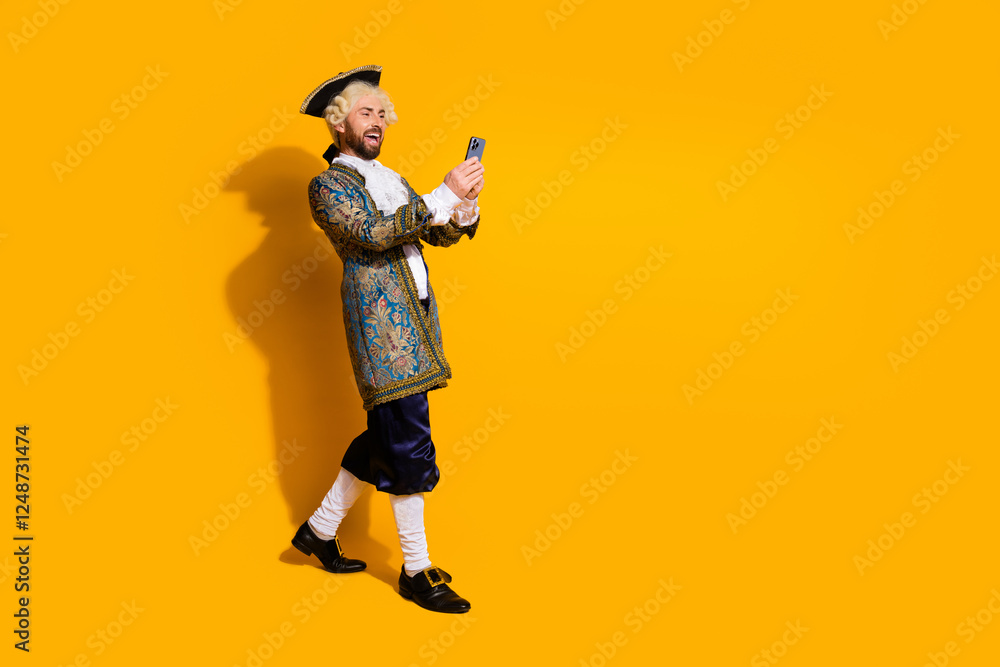 Man in historical costume with smartphone against yellow background combining past era aesthetics with modern technology Man in historical costume with smartphone against yellow background combining past era aesthetics with modern technology