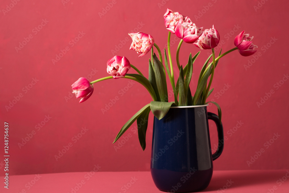 Obraz premium Beautiful pink terry tulips in a metal vintage blue jug