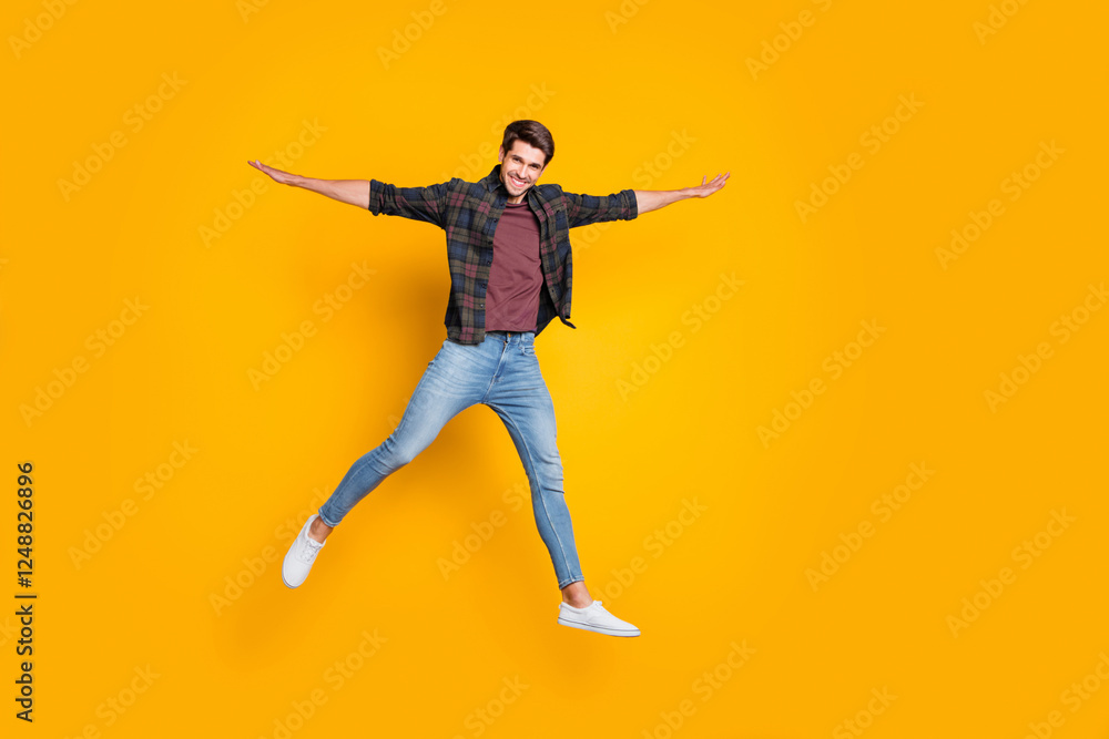 Full length photo of cheerful funny positive man jump hold hand like wings enjoy weekends summer spring holidays wear god-looking outfit isolated over yellow color background Full length photo of cheerful funny positive man jump hold hand like wings enjoy weekends summer spring holidays wear god-looking outfit isolated over yellow color background