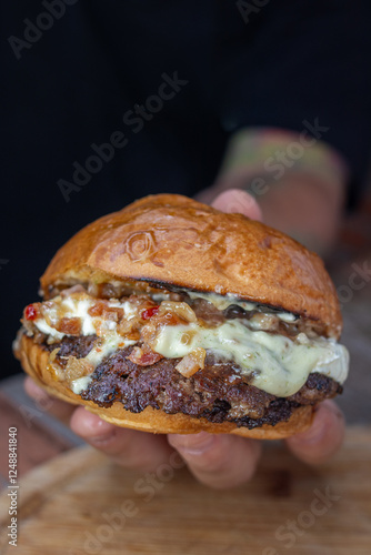 burger with bacon cream cheese being held and shown by a person