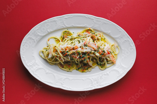 Spaghetti with seafood, crab meat and cream sauce on a beautiful white plate photo