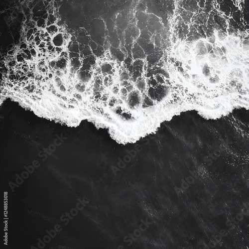 Black and white photograph of ocean waves. Aerial view, dark shore, crashing waves, deep black sea. Top view, abstract background.