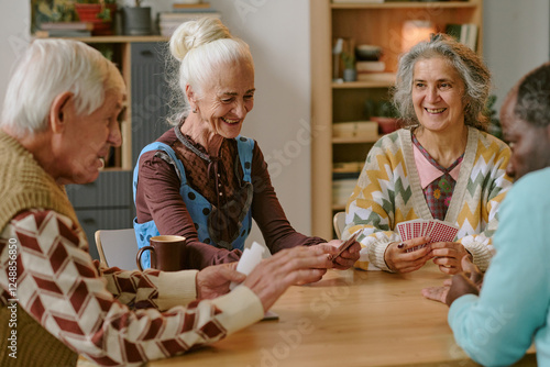 Slika na platnu Senior people smiling and enjoying playing cards together in nursing home