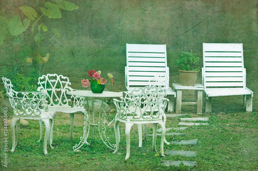 Elegant white painted garden chairs and table set out garden. Elegant white painted garden chairs and table set out garden.