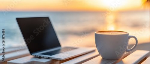 laptop and coffee cup on beach at sunset