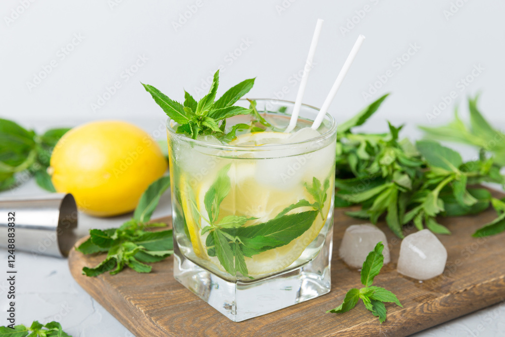 Fototapeta premium Mojito summer refreshing cocktail with ice and mint. mojito cocktail with lime, lemon and mint in a tall glass with a stick