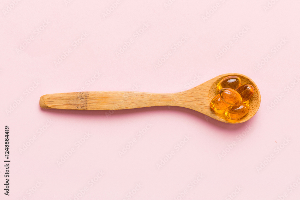 Vitamin omega capsules in a spoon on a colored background. Pills served as a healthy meal. Red soft gel vitamin supplement capsules on spoon Vitamin omega capsules in a spoon on a colored background. Pills served as a healthy meal. Red soft gel vitamin supplement capsules on spoon