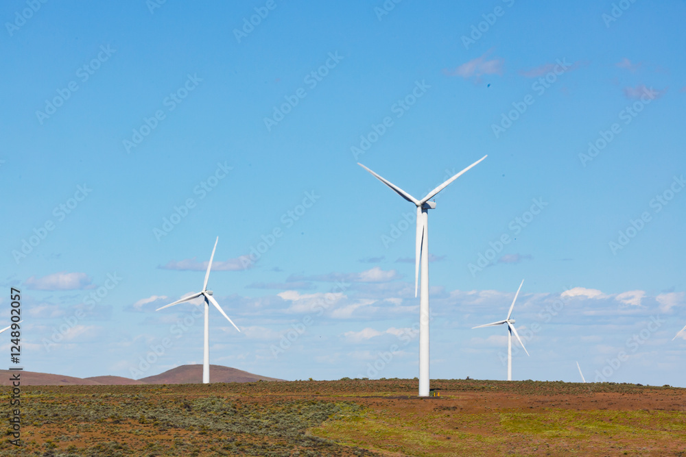 Wind turbines on the rolling hills of Kittikas county in Washington state, tall white towers with blades for energy generation. Wind turbines on the rolling hills of Kittikas county in Washington state, tall white towers with blades for energy generation.