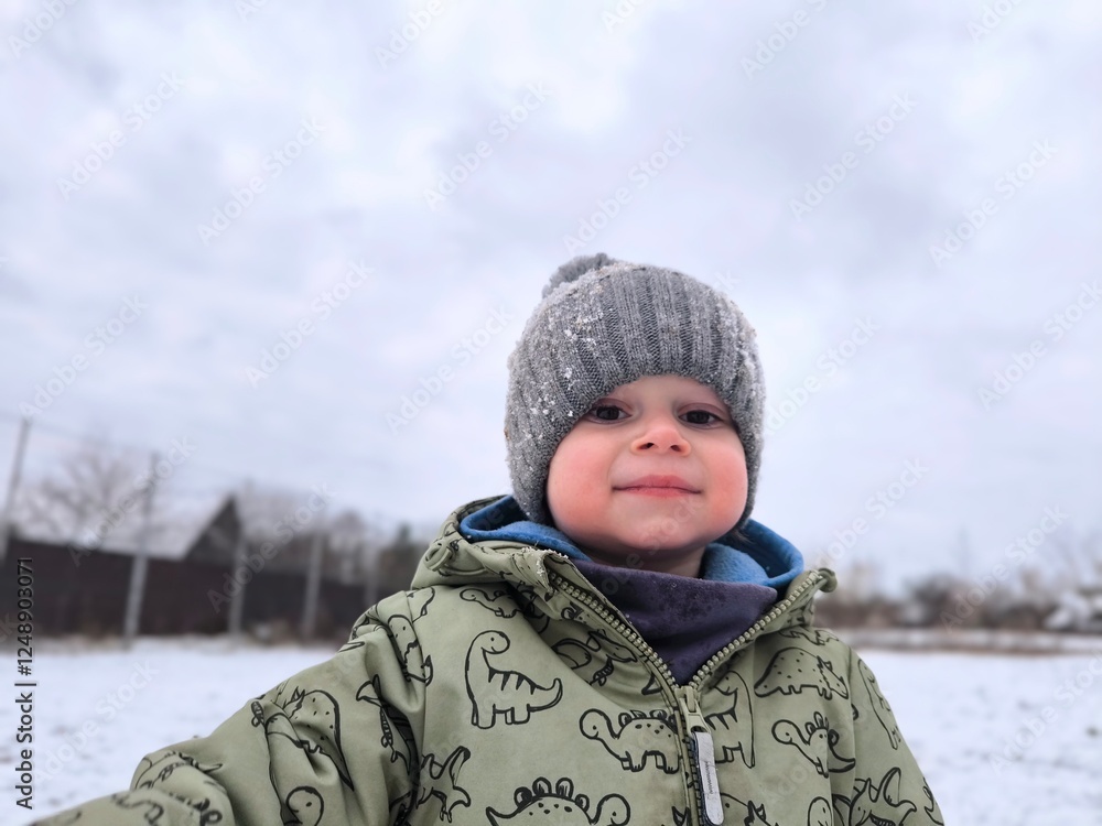 A handsome little boy is outside in winter clothes. Portrait of a little boy in a knitted hat on a background of winter park. Family winter vacation with a child A handsome little boy is outside in winter clothes. Portrait of a little boy in a knitted hat on a background of winter park. Family winter vacation with a child