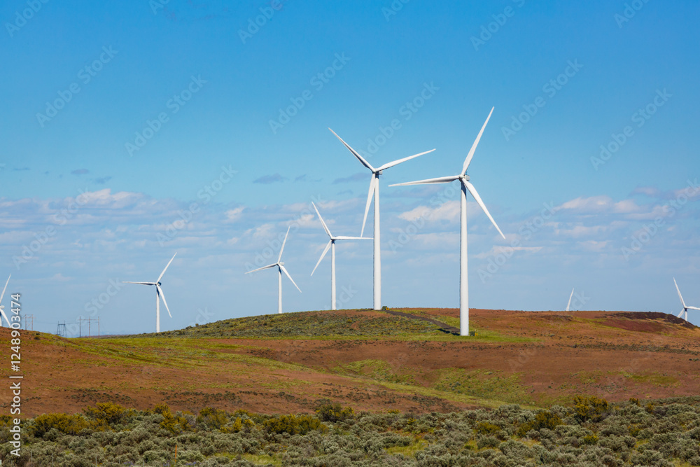 Wind turbines on the rolling hills in Washington state, tall white towers with blades for energy generation. Wind turbines on the rolling hills in Washington state, tall white towers with blades for energy generation.