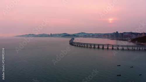 Sunset beauty over Dalian's Xinghai Bay Bridge showcasing aerial views of the coast and skyline photo