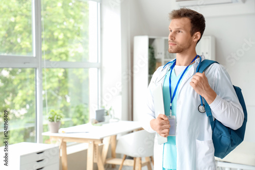 Male medical intern with ba...