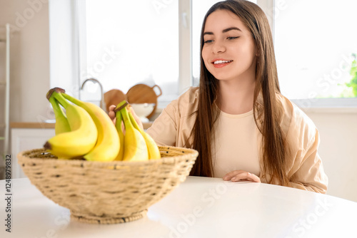 Young woman taking bananas ...