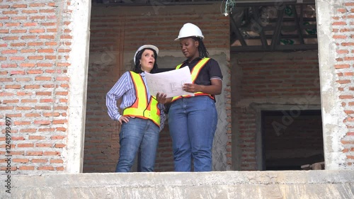 Wallpaper Mural African American foreman woman looking at blueprint with Female Contractor Home Development talking to inspection house in village construction site. team builder examining housing building site. Torontodigital.ca
