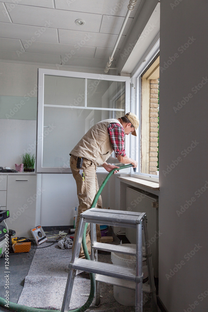 Fototapeta premium Carpenter installing a new window in a family house during renovation and refurbishment.