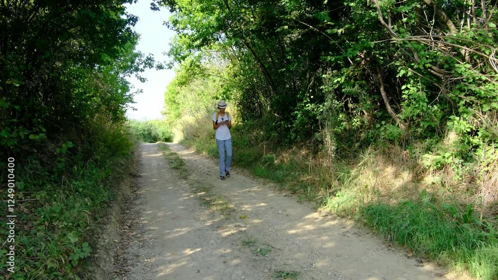Woman hiking through a countryside landscape, surrounded by open fields, fresh air, and peaceful rural scenery. She enjoys the natural beauty and serenity of the outdoors. Woman hiking through a countryside landscape, surrounded by open fields, fresh air, and peaceful rural scenery. She enjoys the natural beauty and serenity of the outdoors.