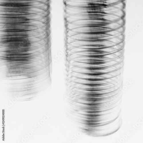 Abstract of metal coiled slinky, length of fine wire wound around and stretched, black and white image. photo