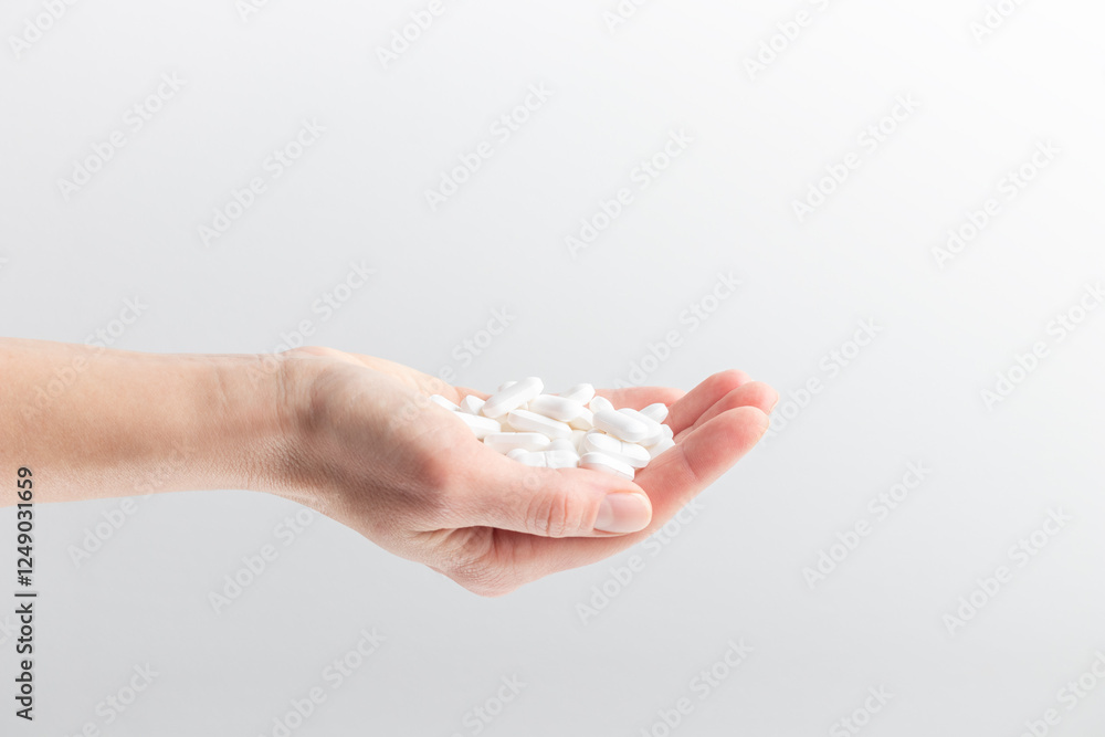 A hand full of white pills in a woman's hands. Concept of health care, dietary supplements, treatment of depression and diseases. High-quality photo banner A hand full of white pills in a woman's hands. Concept of health care, dietary supplements, treatment of depression and diseases. High-quality photo banner