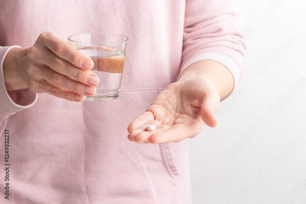 Female taking medicine, holding white pill and a glass of water on white background. Concept of health care, dietary supplements, treatment of depression and diseases. High-quality photo Female taking medicine, holding white pill and a glass of water on white background. Concept of health care, dietary supplements, treatment of depression and diseases. High-quality photo