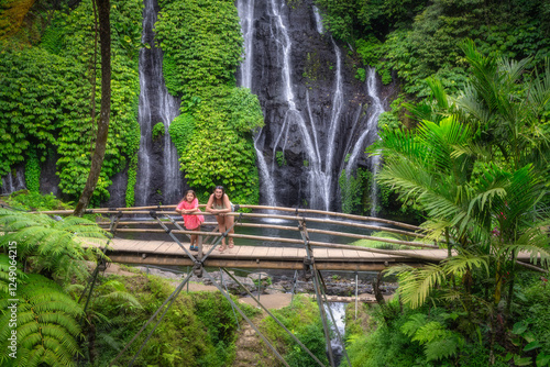 Visitors find joy in a scenic Banyumala Twin Waterfallss view, beautifully framed by lush greenery, making it the perfect peaceful getaway to reconnect with natures beauty, Bali, Indonesia photo