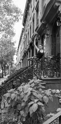Fotografie A dancer framed by vibrant plants, this elegant New York stoop offers a picturesque glimpse into the city's historic residential charm