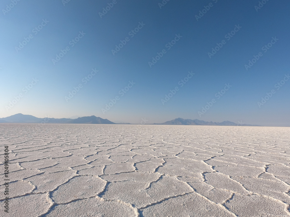 Fototapeta premium A tranquil morning on Bonneville Salt Flats, where the unbroken landscape stretches endlessly beneath a pristine blue sky.